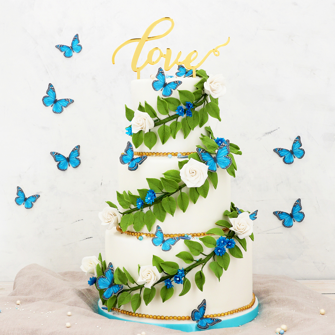 Hohe Torte mit Blumenranken und Schmetterlingen.