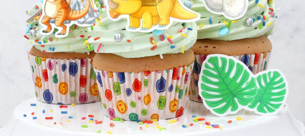 Auf dem Bild sieht man leckere Cupcakes dekoriert mit süßen Dinosauriern aus Wafer Paper