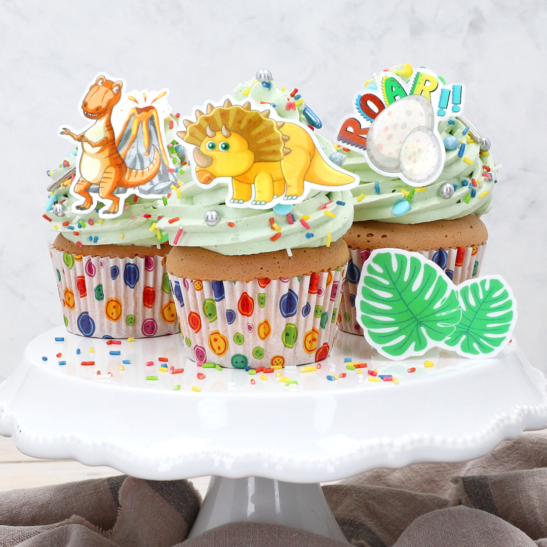 Auf dem Bild sieht man leckere Cupcakes dekoriert mit süßen Dinosauriern aus Wafer Paper