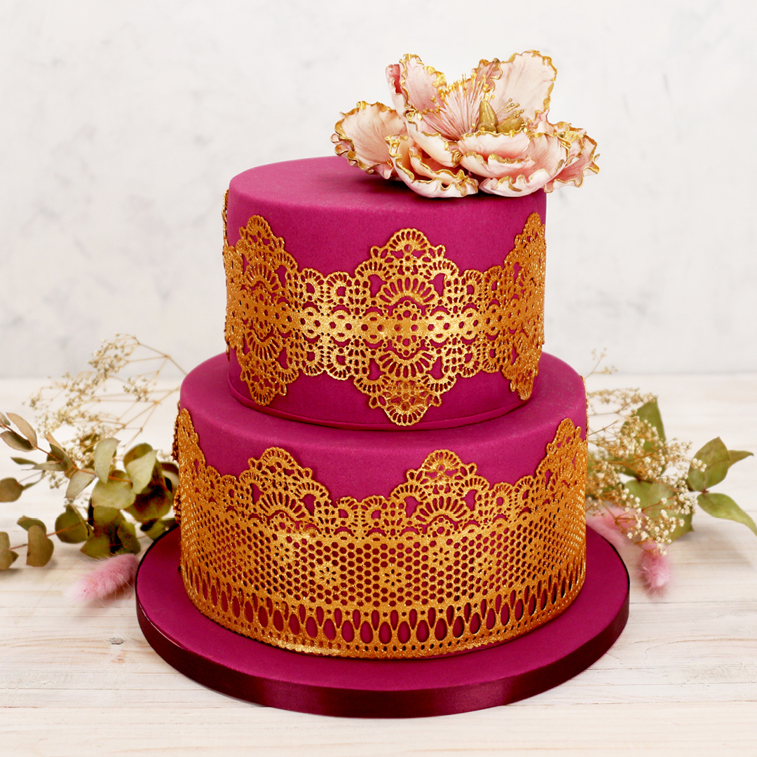 Das Bild zeigt eine Torte mit goldener Spitze verziert