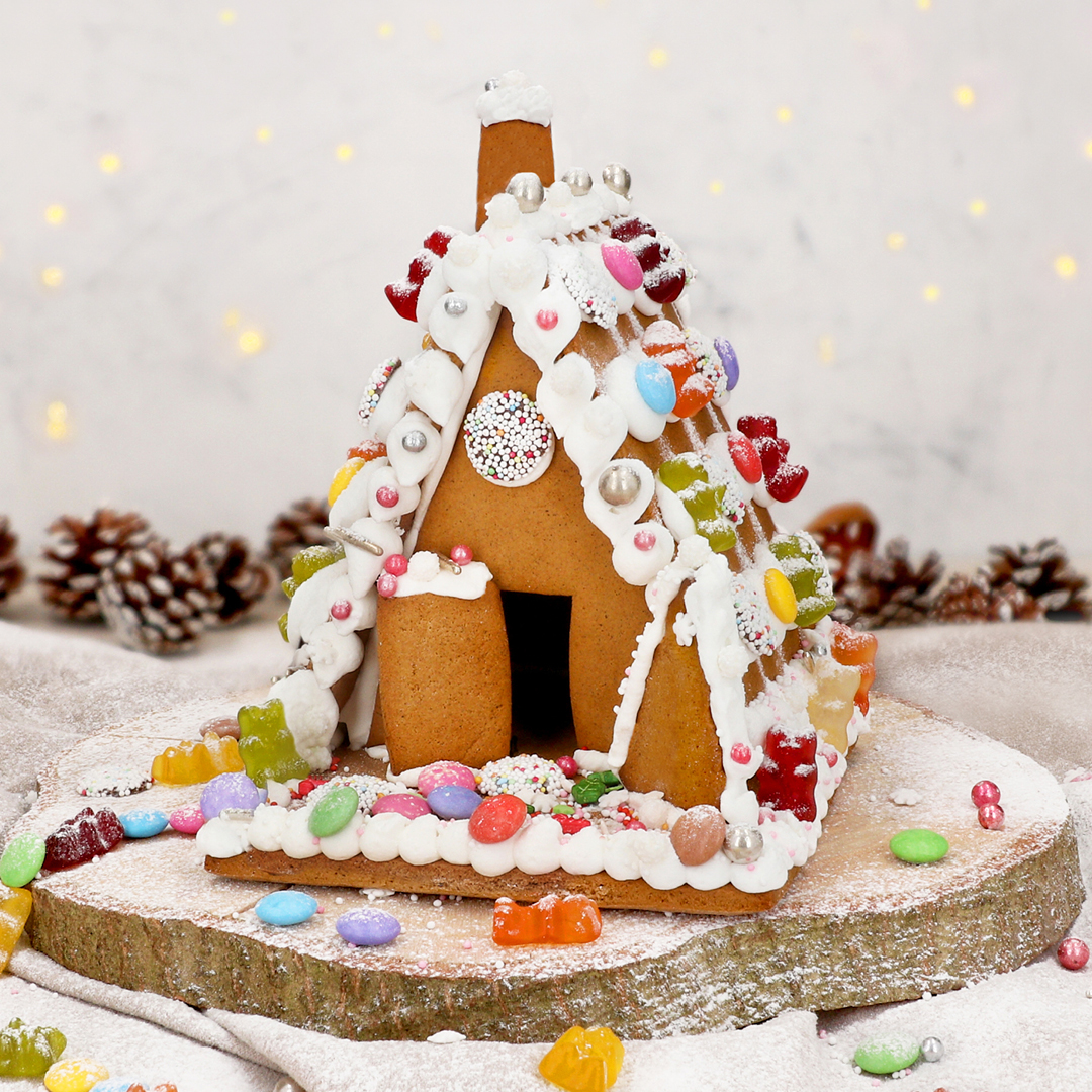 Das Bild zeigt ein knuspriges Lebkuchenhaus mit süßer Dekoration.
