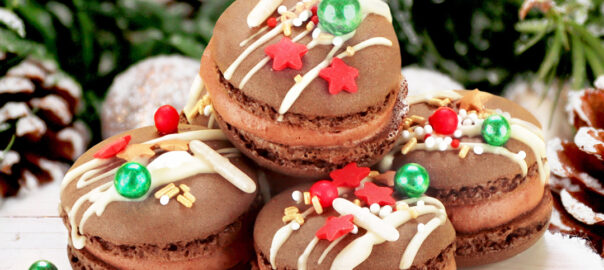 Das Bild zeigt unsere schokoladigen Santa's Schoko-Macarons mit süßen Sprinkles.