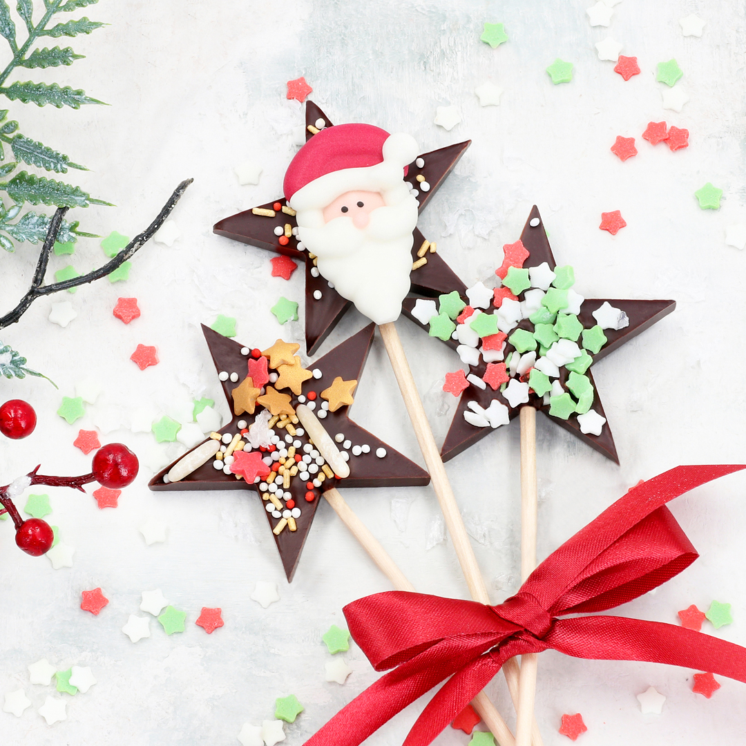 Das Bild zeigt schokoladige Lollis in sternform mit Nikolaus Dekoren.