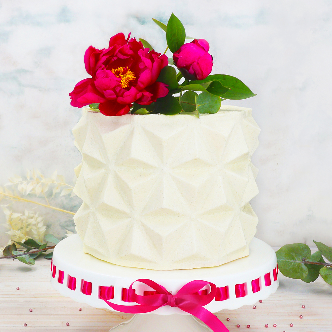 Das Bild zeigt eine Torte im 3D Effekt, die mit einer Origami-Schablone gezaubert wurde