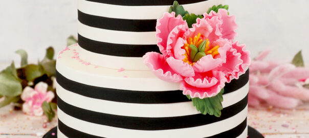 Das Bild zeigt eine Torte auf der ein Blumenbouquet aus Feinzucker liegt