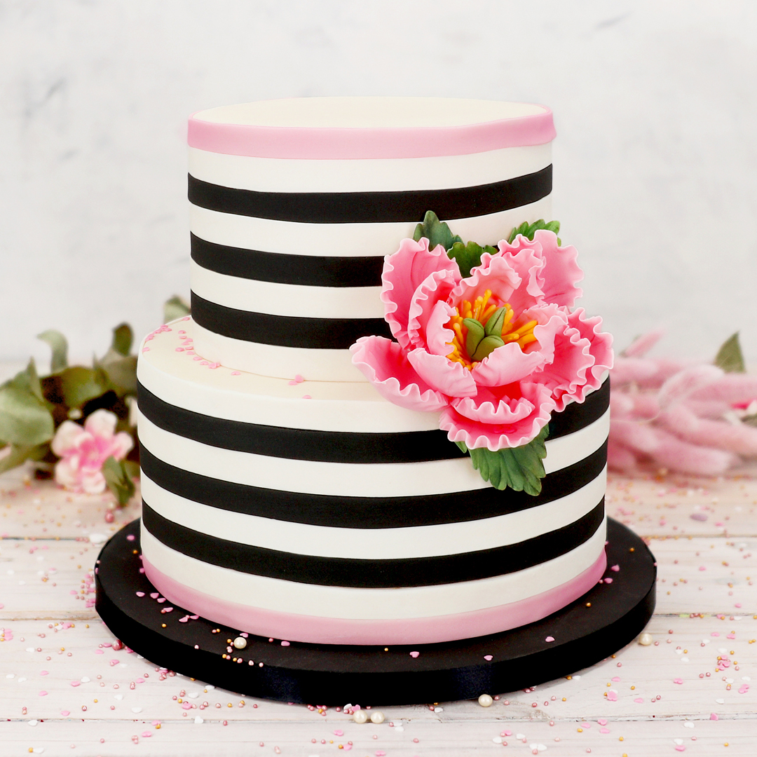 Das Bild zeigt eine Torte auf der ein Blumenbouquet aus Feinzucker liegt