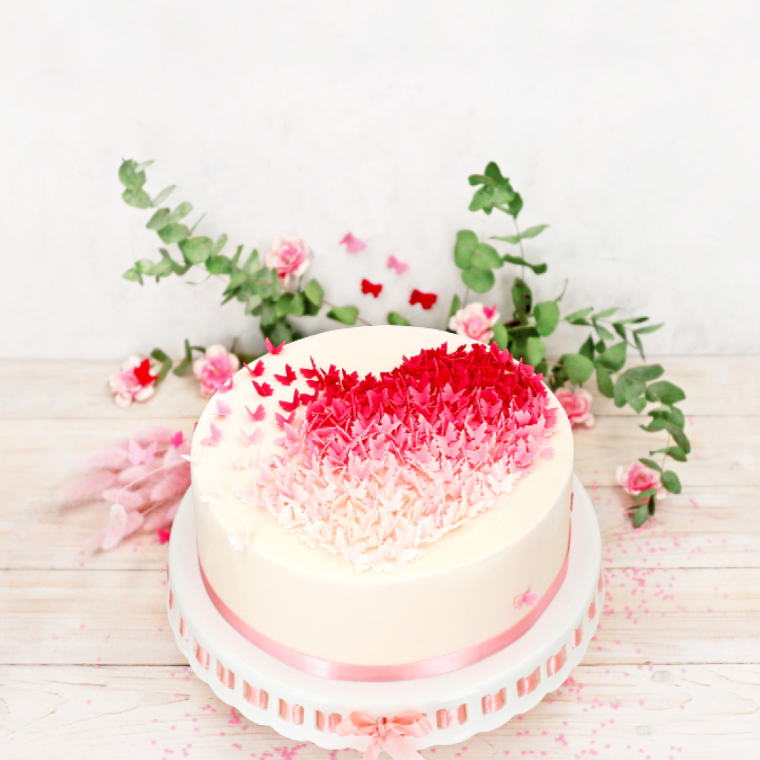 Das Bild zeigt eine Fondanttorte mit vielen kleinen Schmetterlingen