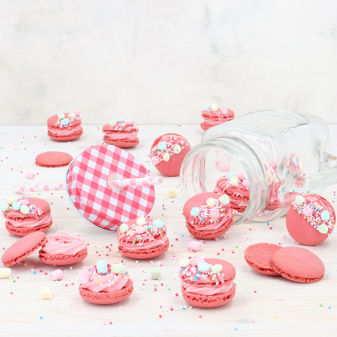 Das Bild zeigt Macarons mit einer Erdbeer-Ganache und verziert mit bunten Sprinkles