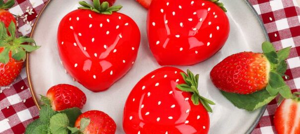 Das Bild zeigt kleine Erdbeer-Cremetörtchen als Erdbeeren dekoriert