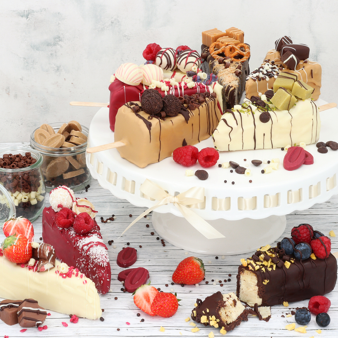 Das Bild zeigt eine Reihe an Cheesecake-Stücken am Stiel