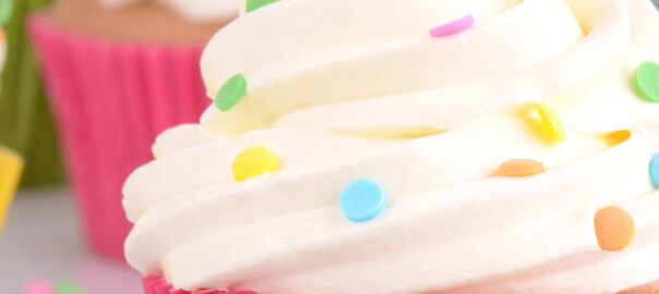 Das Bild zeigt Cupcakes, die eine Haube aus Buttercreme haben und mit Sprinkles verziert wurden