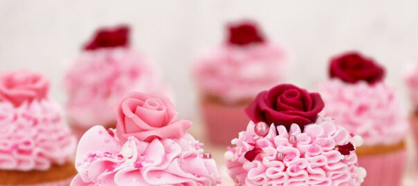 Das Bild zeigt Cupcakes die mit Marzipan-Rosen dekoriert wurden.