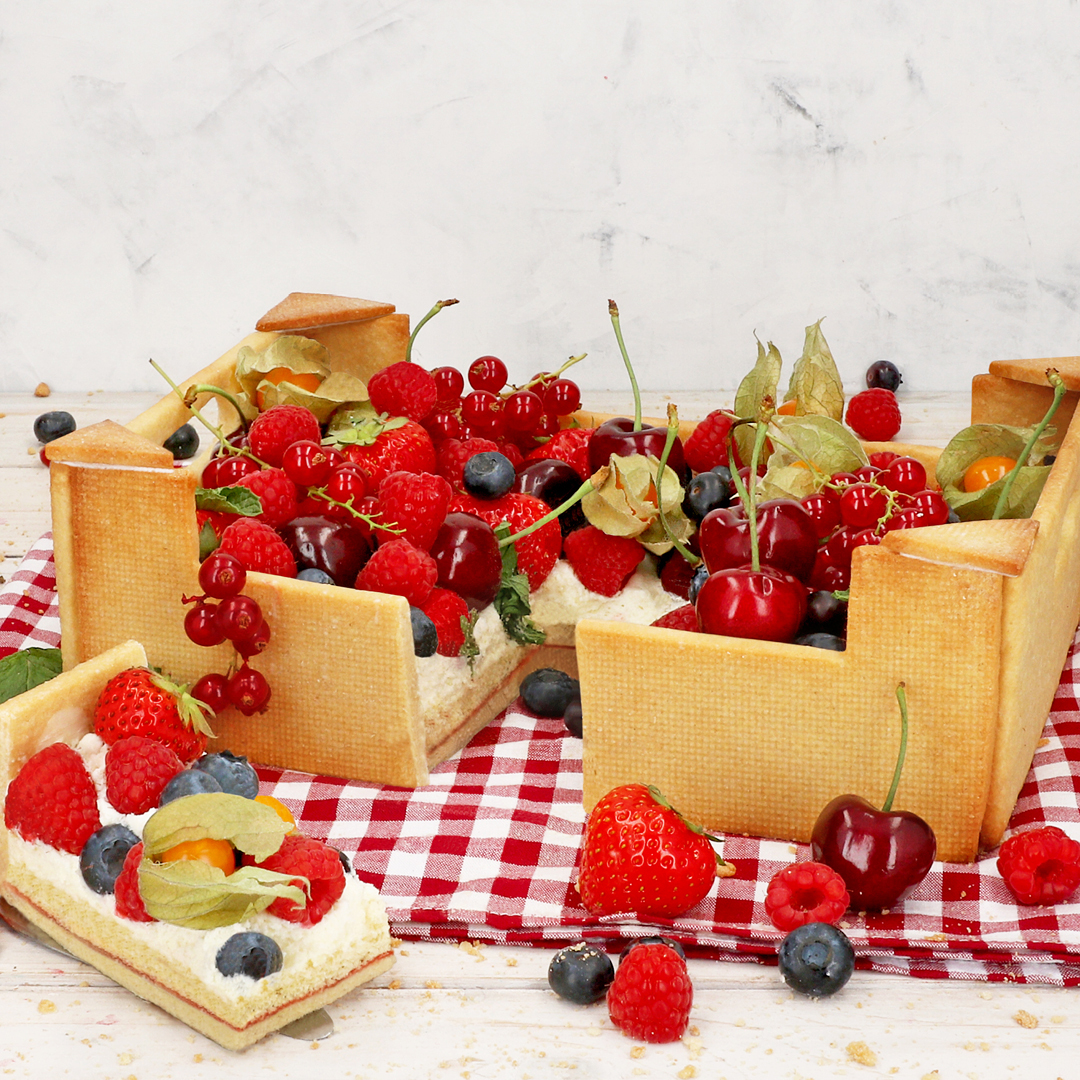 Das Bild zeigt eine Torte, die wie eine Obstkiste aussieht