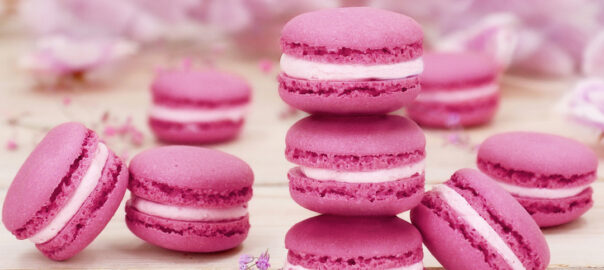 Das Bild zeigt pinke Macarons mit einer rosa farbenden Ganache