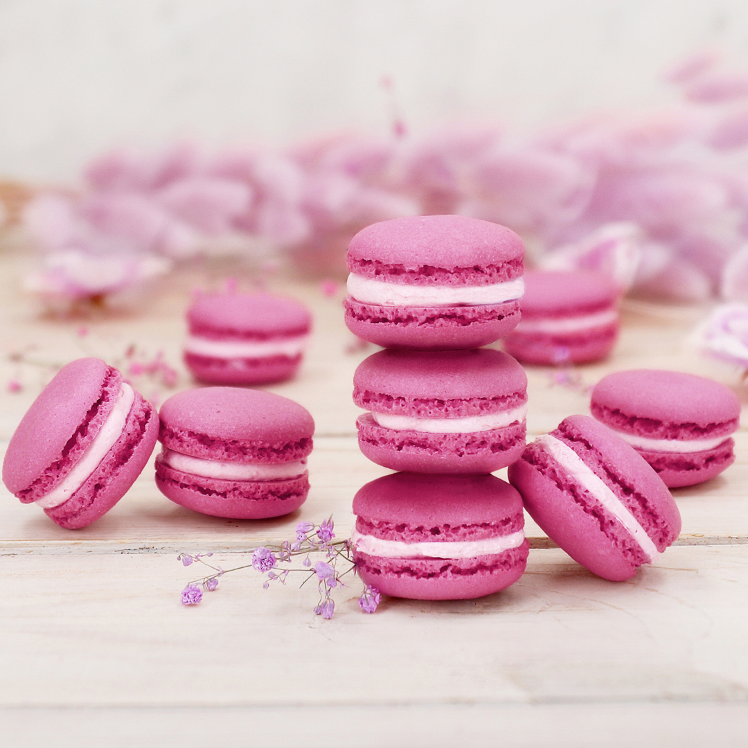 Das Bild zeigt pinke Macarons mit einer rosa farbenden Ganache