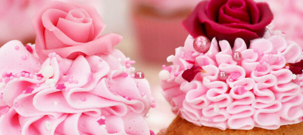 Das Bild zeigt Cupcakes mit einer Creme und Rosen aus Marzipan